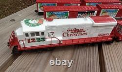 Un ensemble de train de Noël Charlie Brown en O gauge avec des wagons Lionel, une locomotive Snoopy et un fourgon de queue.