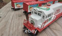 Un ensemble de train de Noël Charlie Brown en O gauge avec des wagons Lionel, une locomotive Snoopy et un fourgon de queue.