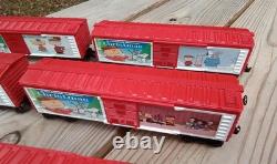 Un ensemble de train de Noël Charlie Brown en O gauge avec des wagons Lionel, une locomotive Snoopy et un fourgon de queue.
