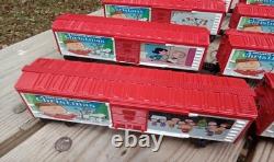 Un ensemble de train de Noël Charlie Brown en O gauge avec des wagons Lionel, une locomotive Snoopy et un fourgon de queue.